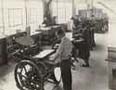 Men and woman operating printing equipment, circa 1920