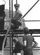 Man on scaffold, wiring lights at 1966 Cassis Festival