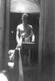 Jerome Hill, self portrait, Antibes: Standing at table, arm blurred