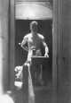 Jerome Hill, self portrait, Antibes: Standing at table, one arm behind back (2)