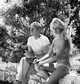 Jerome Hill with Brigitte Bardot, at Cassis, sitting on wall, looking away
